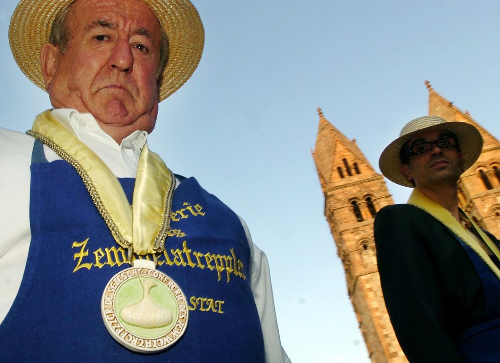 Members of the Zewwelatrepple onion <em>confrérie,</em> sporting the straw hat and onion-emblazoned medal of the group. 