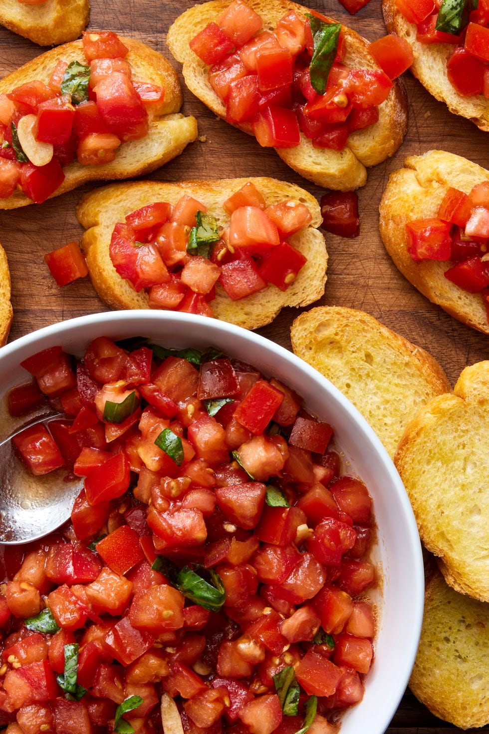 bruschetta spooned on top of slices of a toasted baguette