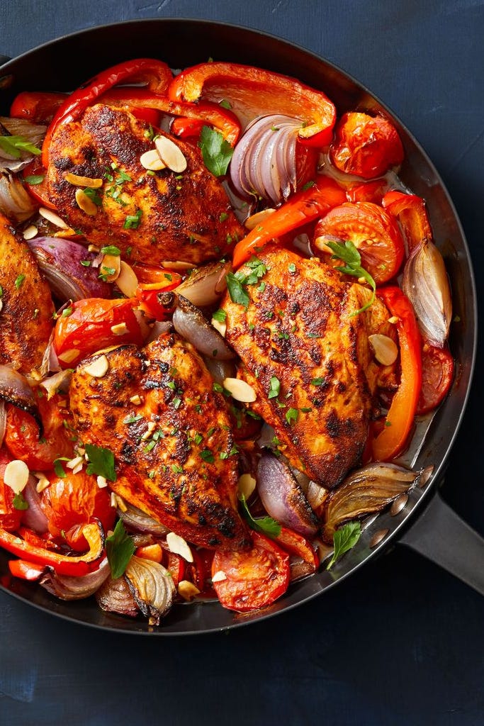 chicken with stewed peppers and tomatoes on a skillet