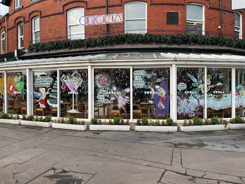Window paintings of fairies and other whimsical characters decorating a Croma restaurant.