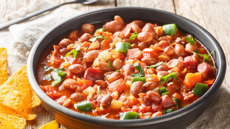 A fresh bowl of ranchero beans with a couple of tortillas on the side