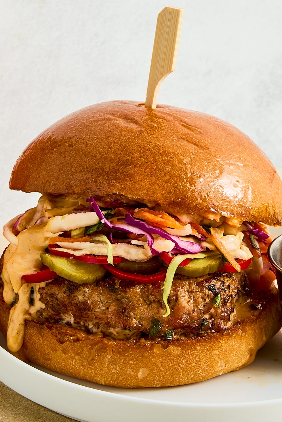 a ginger, garlic, and scallion studded turkey patty, pickled spicy peppers and cucumbers, a bright, crisp cabbage slaw, and plenty of sweet chili mayo all on a shiny, fluffy brioche bun