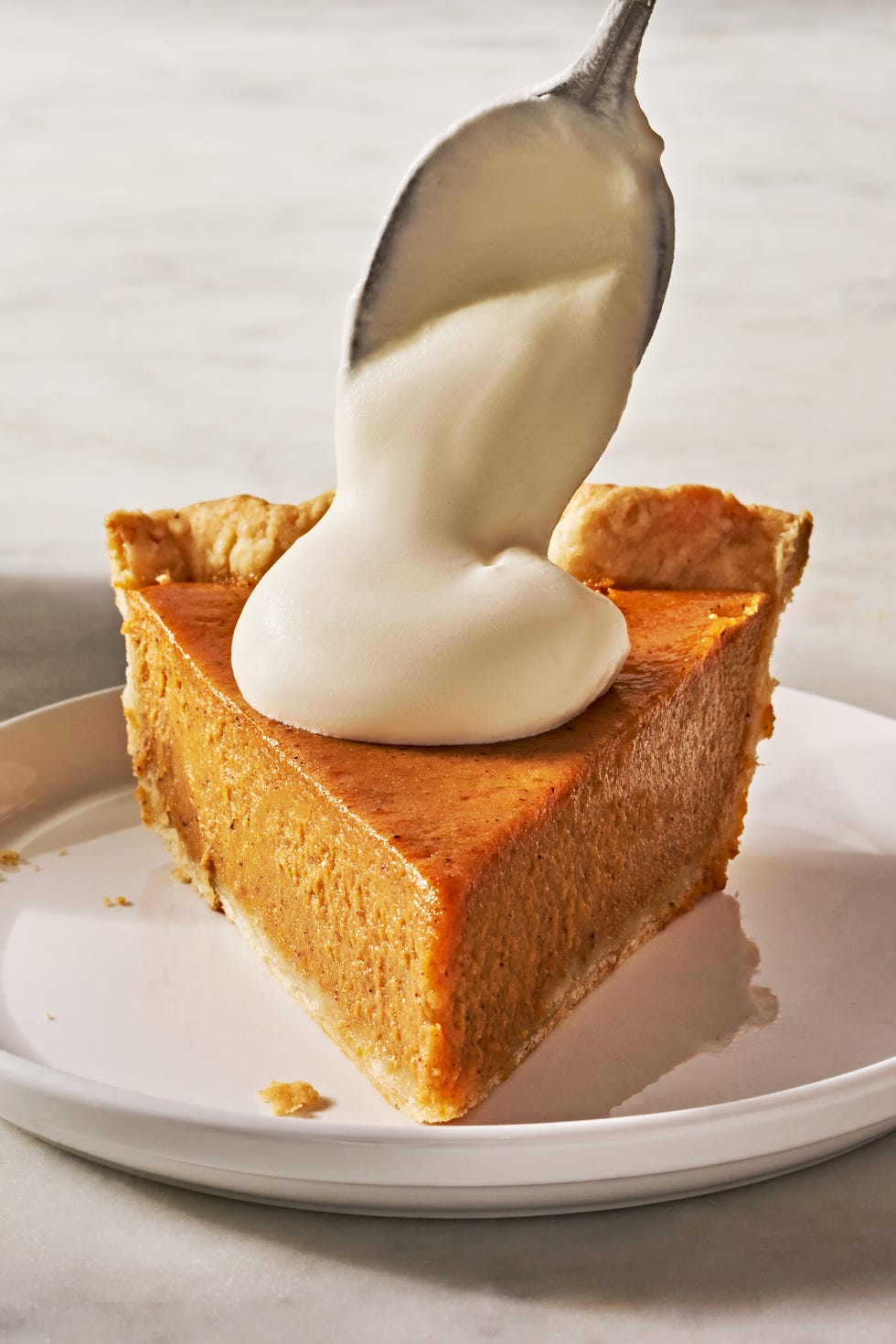 sweet potato pie slice on a plate dolloped with whipped cream