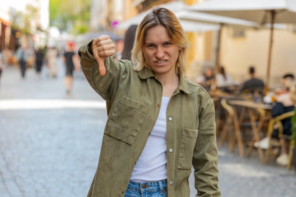 A woman flashing a thumbs-down gesture.