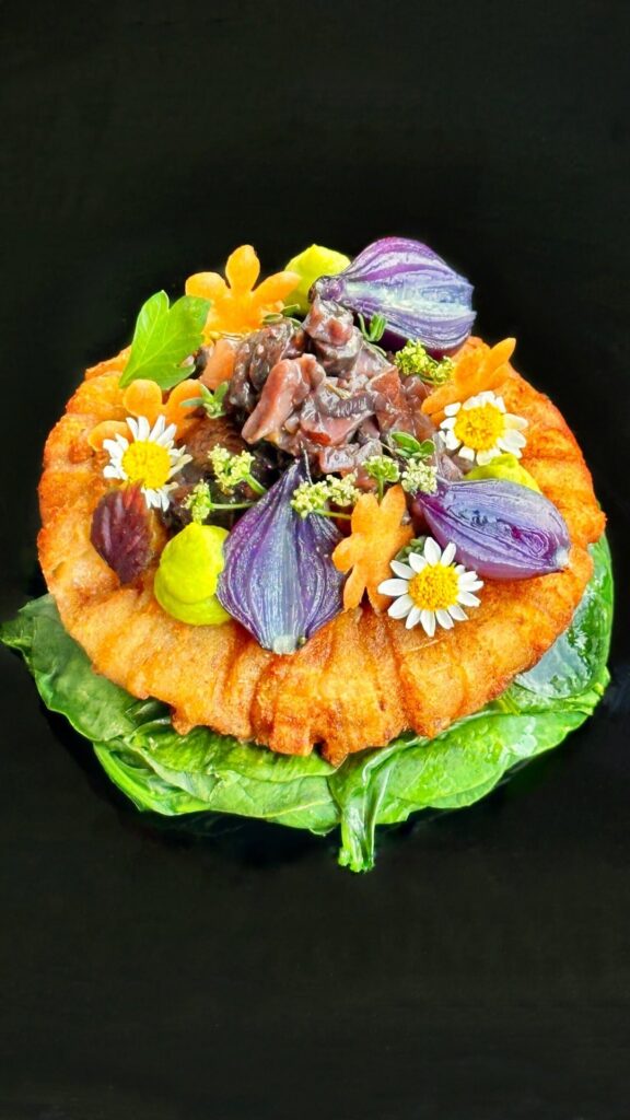 Crispy herb yukon ring, mushroom duxelle, malt vinegar fluid gel, English pea purée, glazed pearl onions, and wilted spinach.