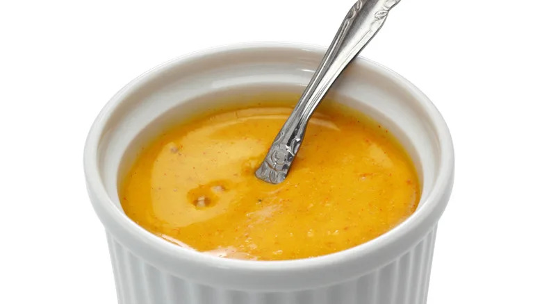 White ramekin with a spoon filled with rouille sauce