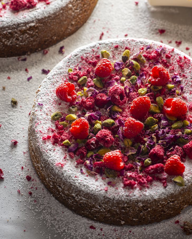 cake with icing sugar and berries on top