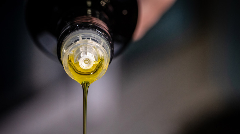 Person pouring olive oil from a bottle