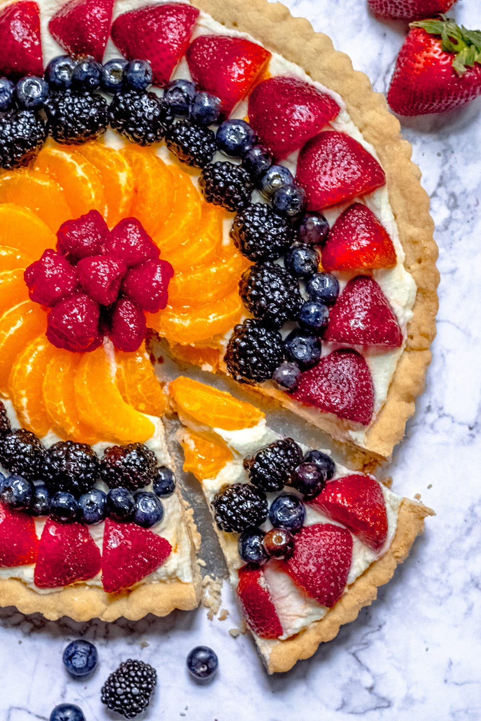 shortbread crust fruit tart topped with strawberries, blueberries, raspberries, and orange wedges