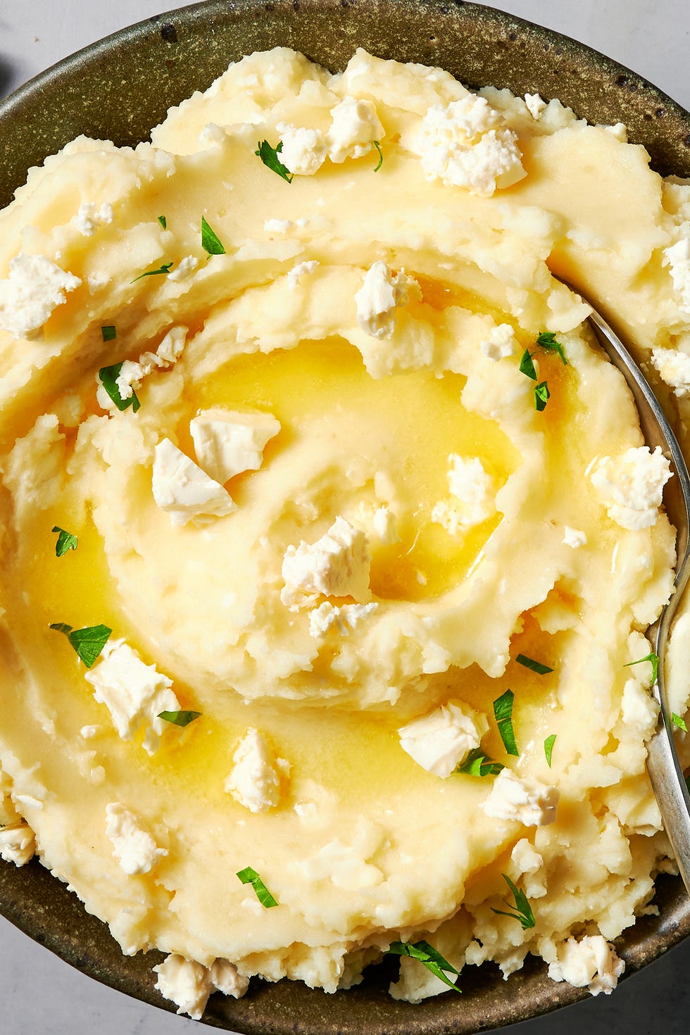 bowl of creamy mashed potatoes topped with feta crumbles