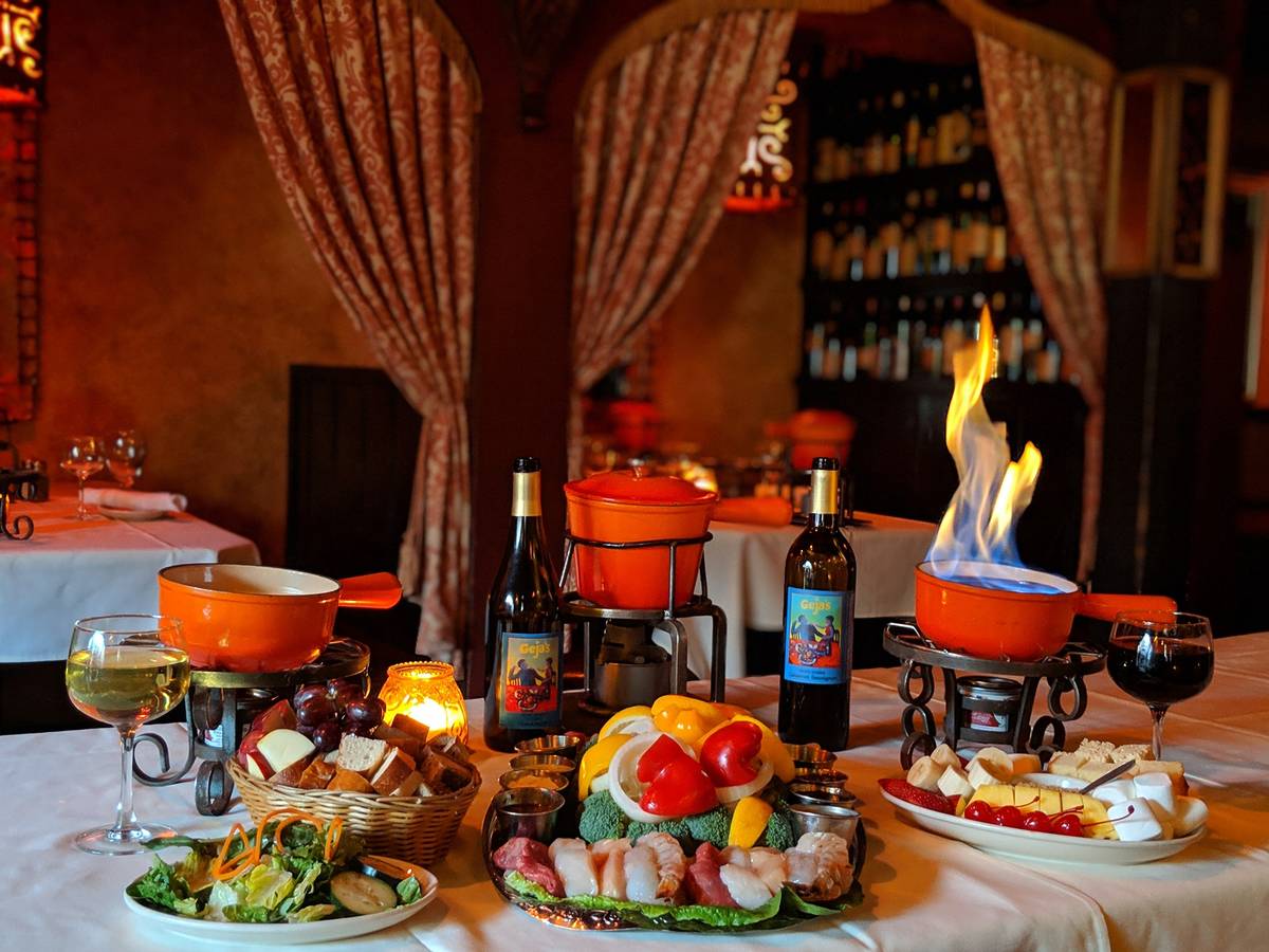 orange fondue pots with meat skewers and bottles of wine from Gejas Cafe