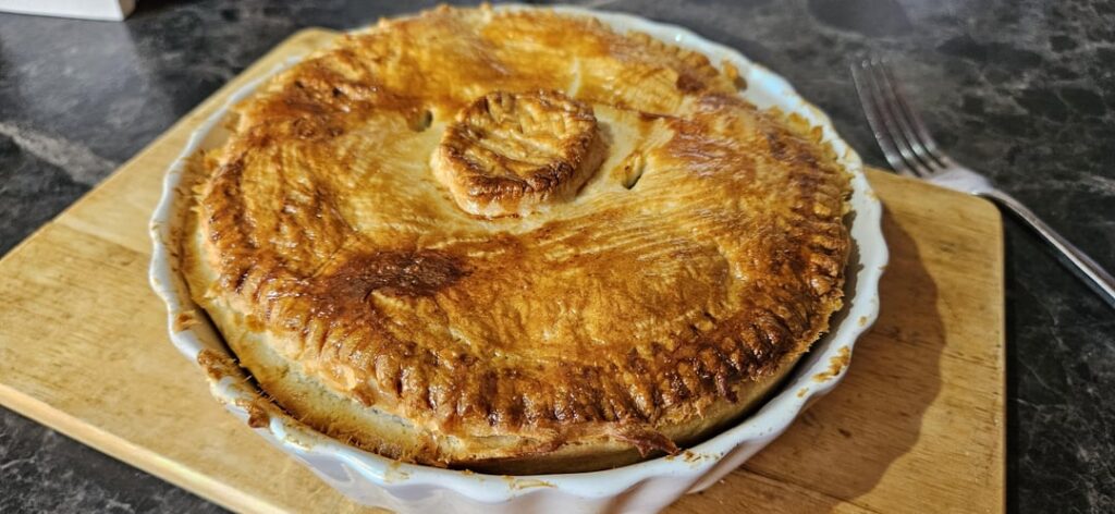 Chicken, bacon and leek pie with garlic butter new potatoes and peas