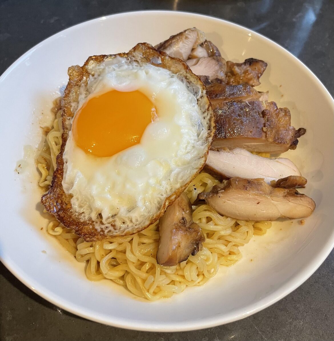 Indomie, leftover grilled chicken, fried egg — A hearty breakfast