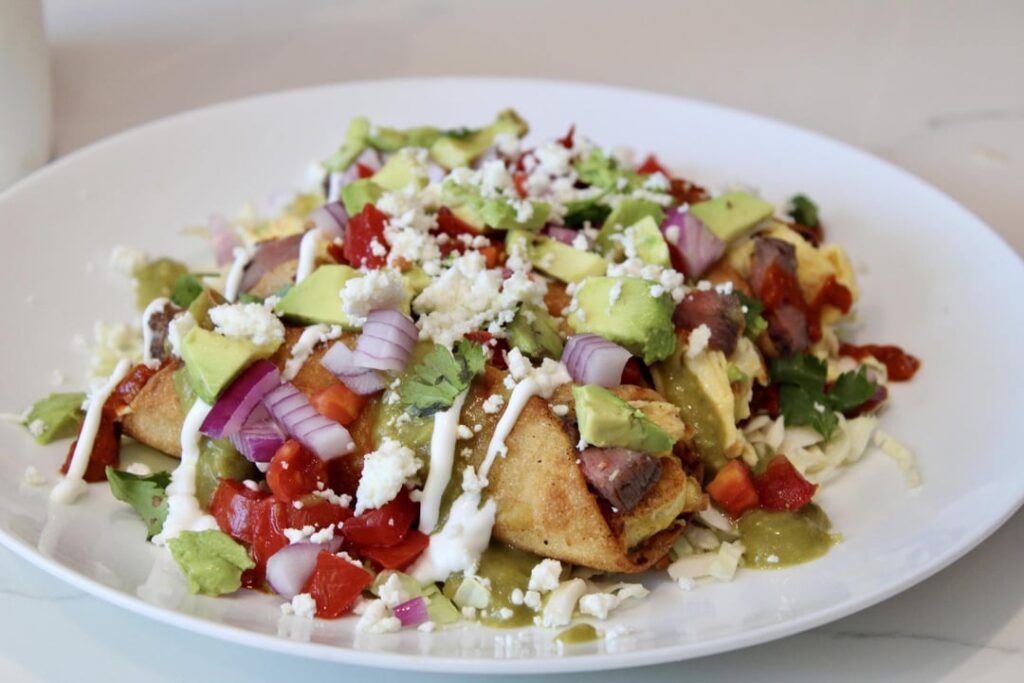 Rolled steak and egg tacos, with homemade green sauce and red sauce.