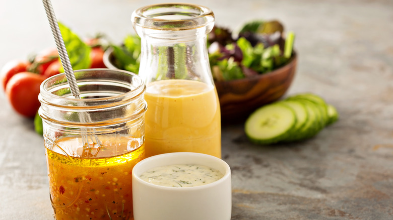 three jars filled with salad dressing