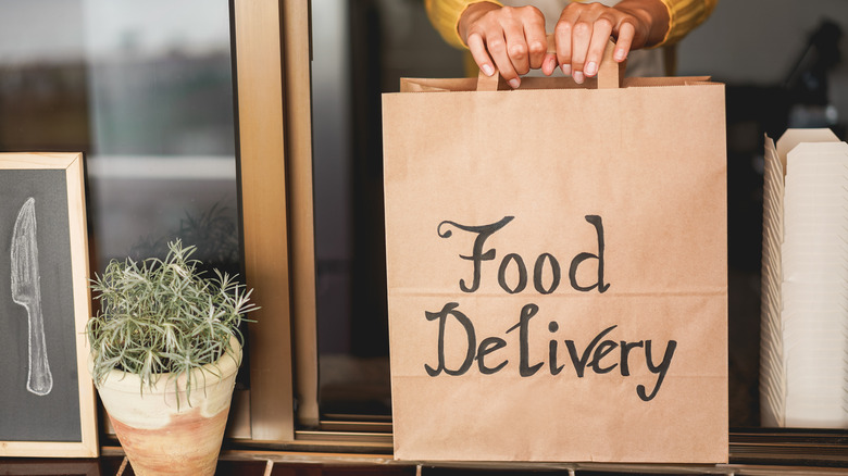 Person handing off food delivery bag