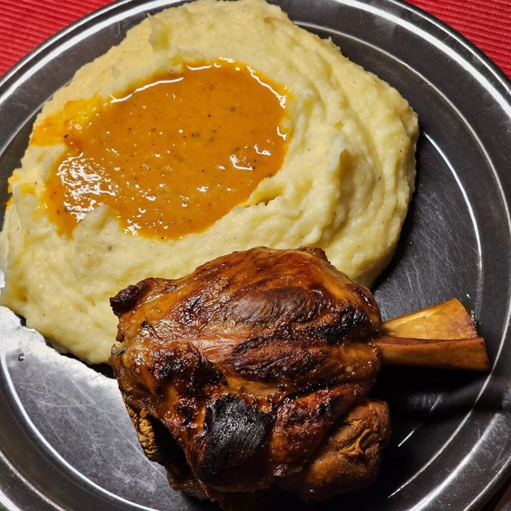 "Mount Mashed at Lake Sauce": Pork knuckle with homemade mashed potatoes at a spicy veggies-chilli sauce