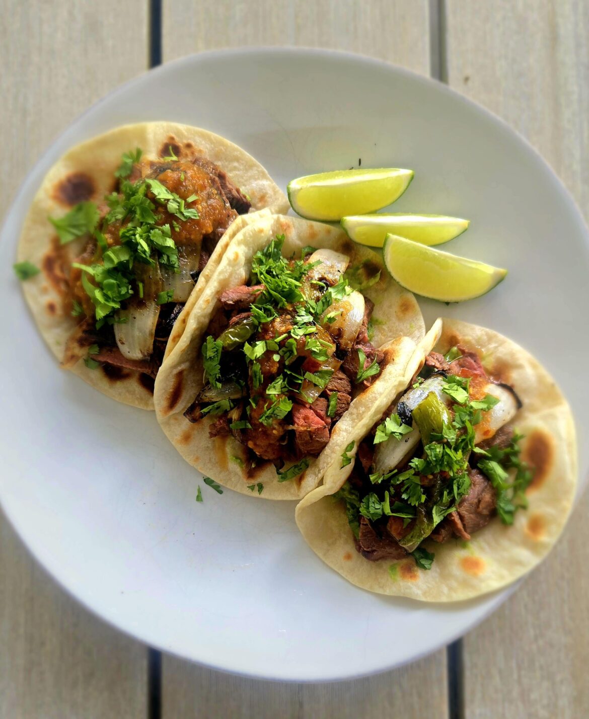Carne asada, grilled onion and Serrano peppers on flour tortillas