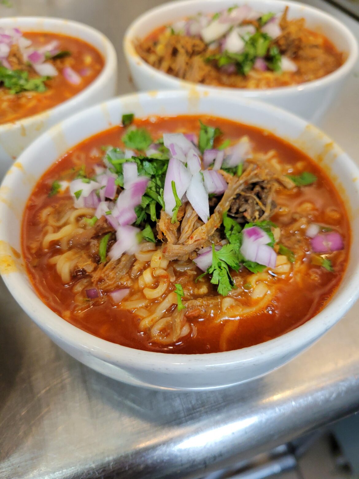 Birria ramen with onion and cilantro