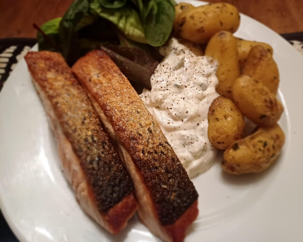 Pan seared salmon with garlic butter new potatoes, tzatziki and leaves.