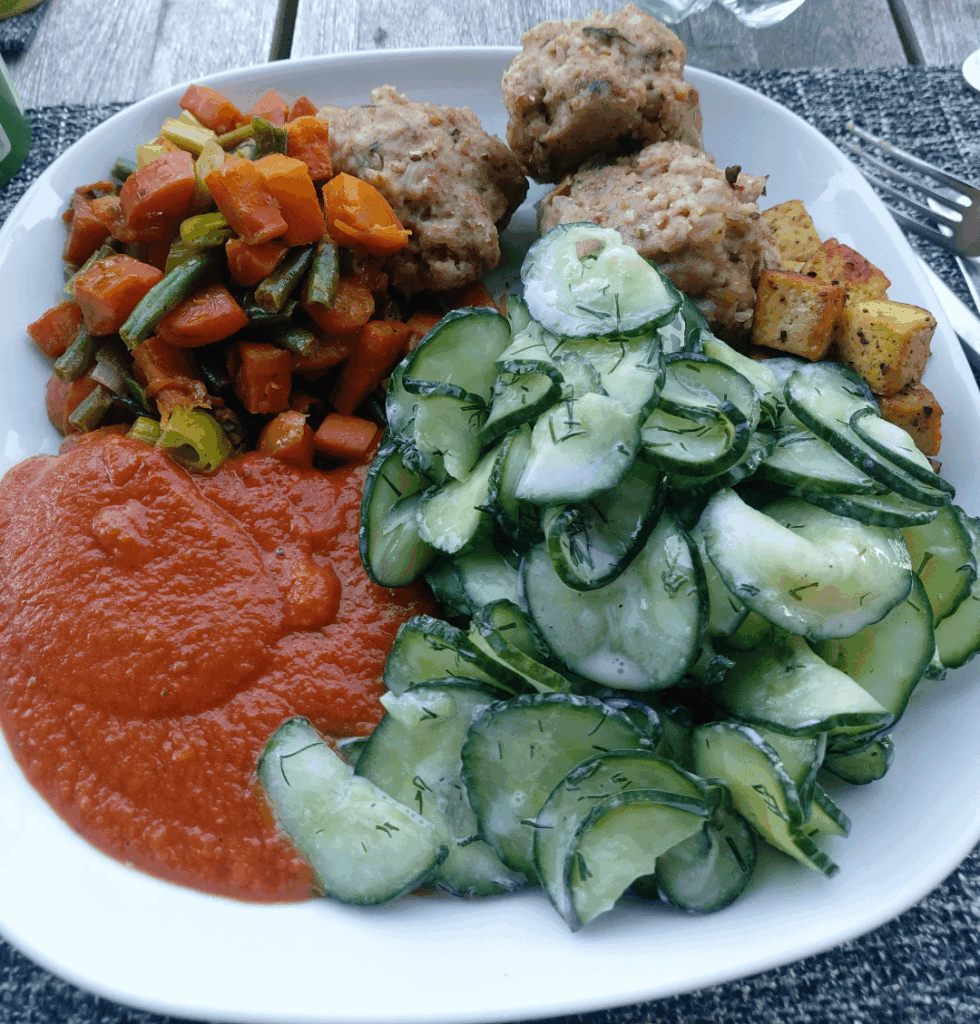 German dumplings, cucumber salad, roasted tofu, mixed veggies and tomato sauce.