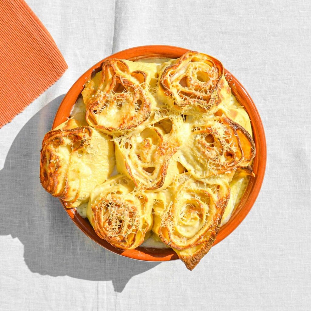 Rosette al forno - baked Modenese pasta roses filled with fontina, Parmigiano Reggiano, prosciutto cotto, and béchamel