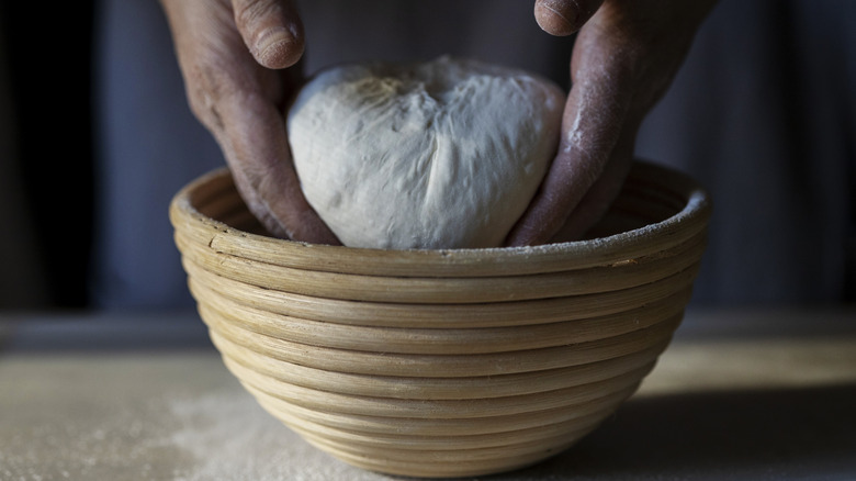 Person placing raw dough in a bowl