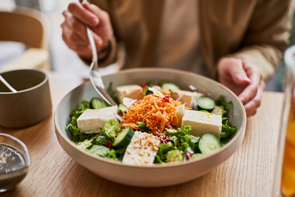 Person eating an organic tofu salad.