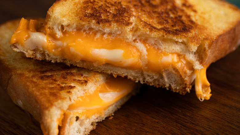 A lightly-browned grilled cheese sandwich on a wooden surface.