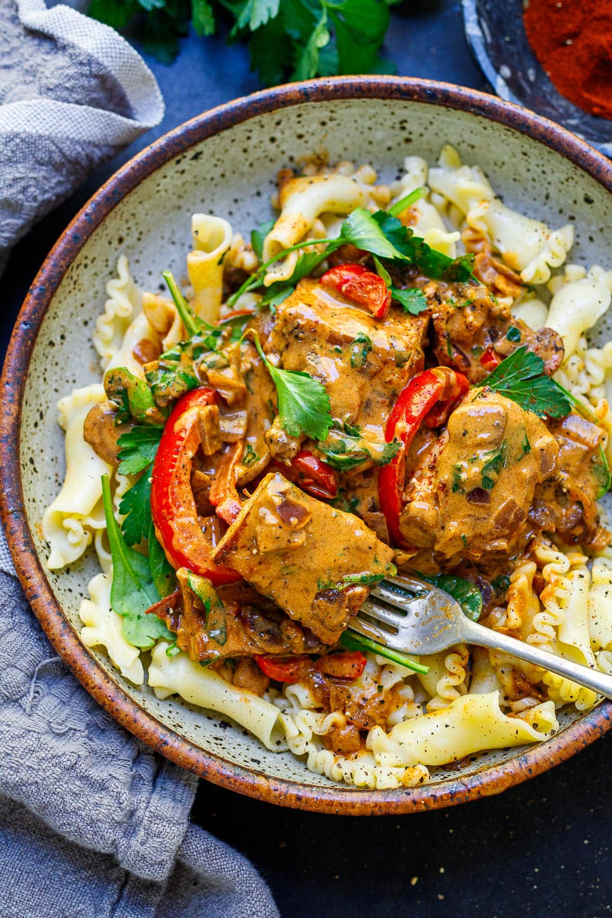 tofu paprikash served over pasta with red peppers, parsley, spinach.