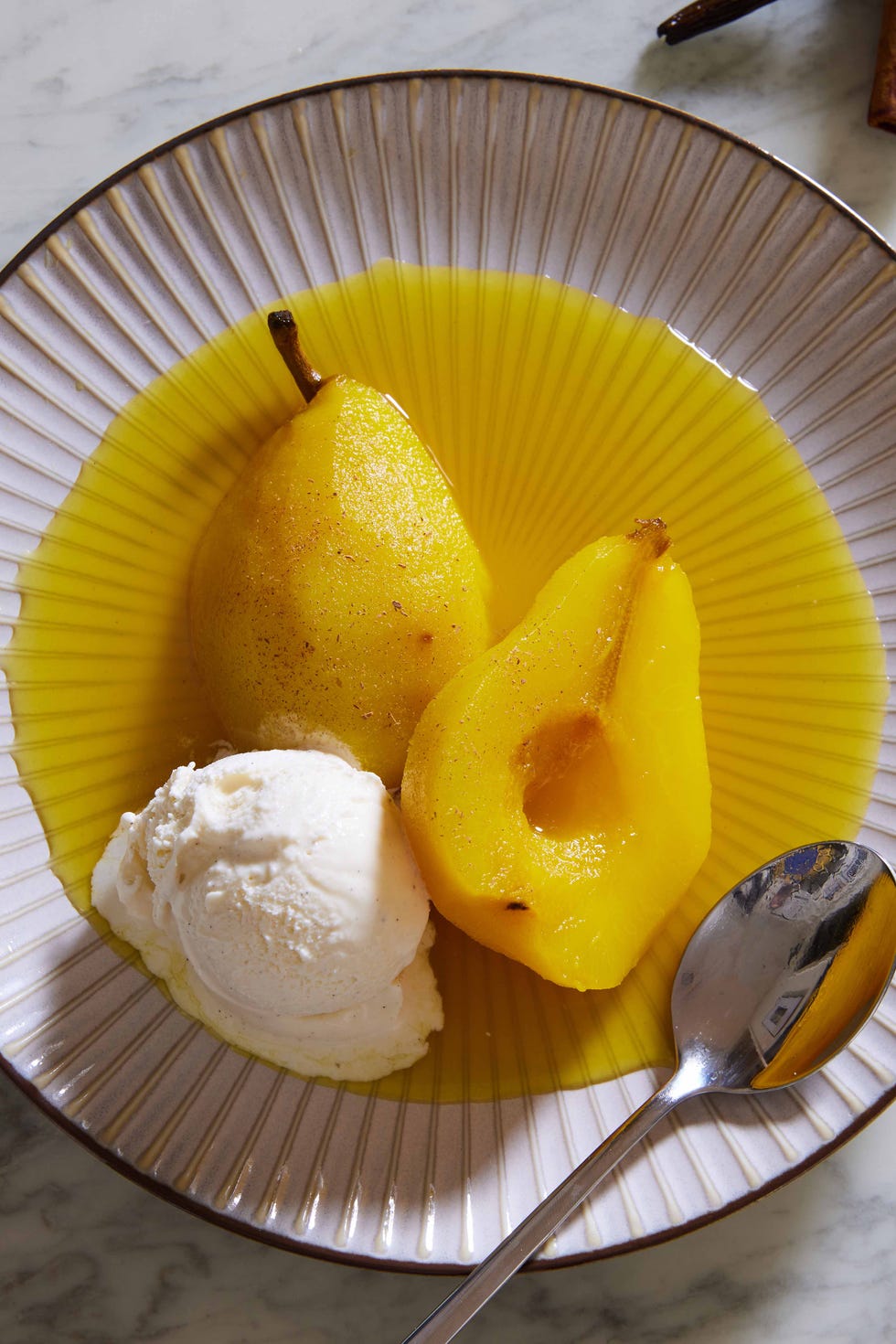 golden poached saffron pears with vanilla ice cream