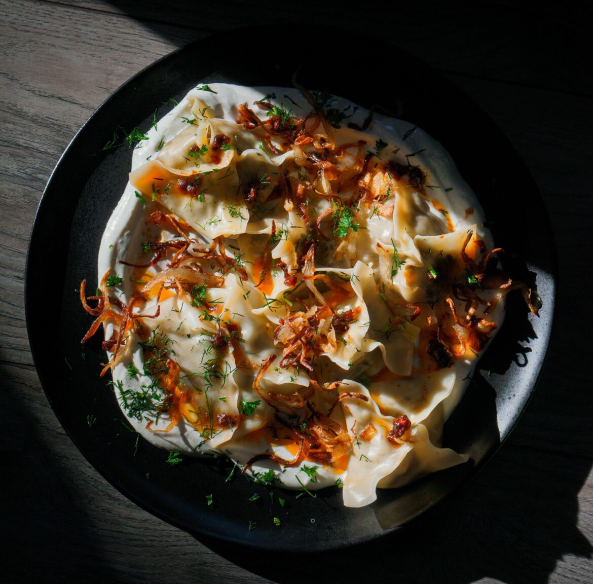 Turkish manti beef dumplings, garlic and herb labne, chili oil, crispy shallots.