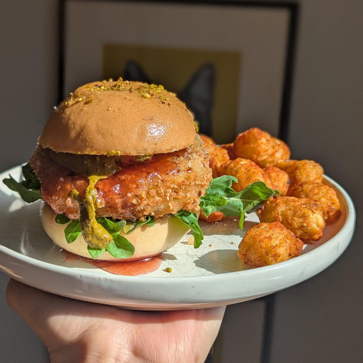fried tofu sandwich with smoked pistachio butter and raspberry gastrique, plus a side of smoky paprika tots.