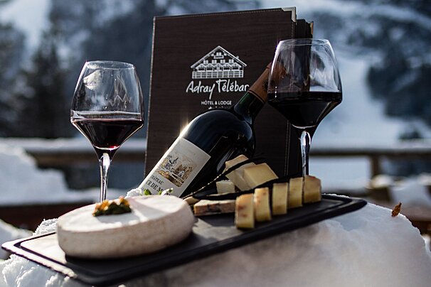 A bottle of wine sits on a table next to two glasses of wine