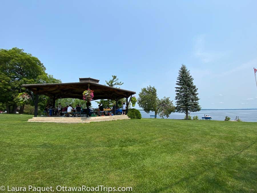 a gazebo, trees and parkland with river in background.