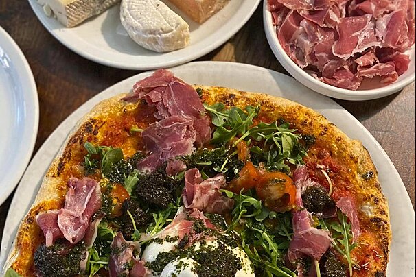 A pizza with a lot of meat and vegetables on it