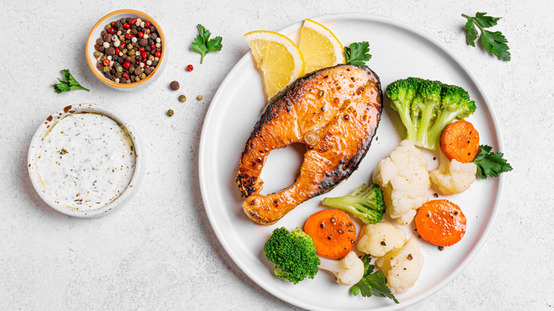 Grilled salmon on a plate with tzatziki side