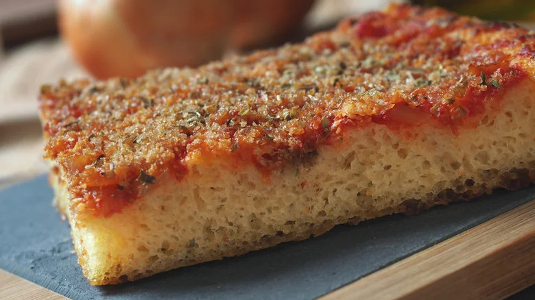 Slice of sfincione on a cutting board