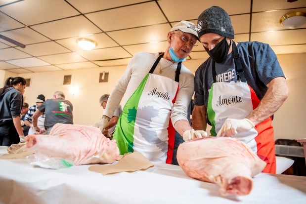 Joseph Almonte Sr. helps his son Joseph Almonte Jr. during a prosciutto-making class. 