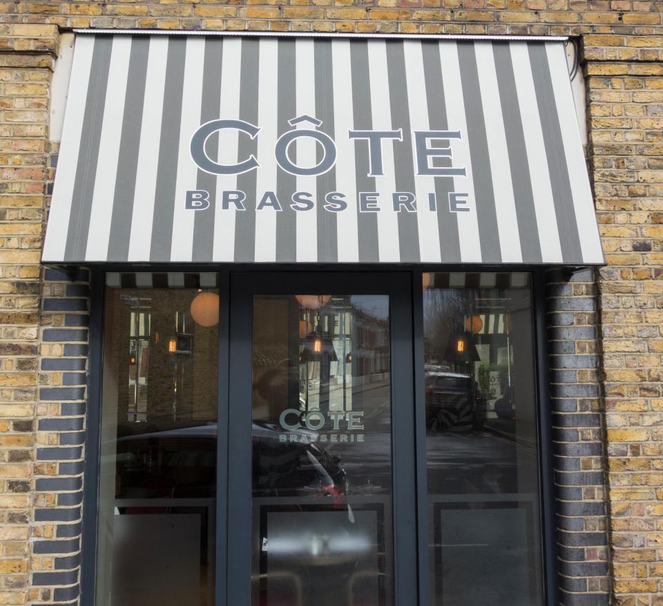 Cote Brasserie storefront with striped awning.