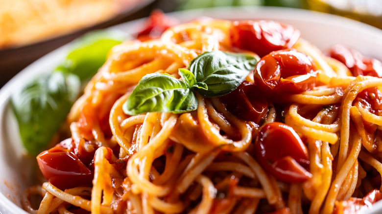 Spaghetti dish in tomato sauce with sprig of basil
