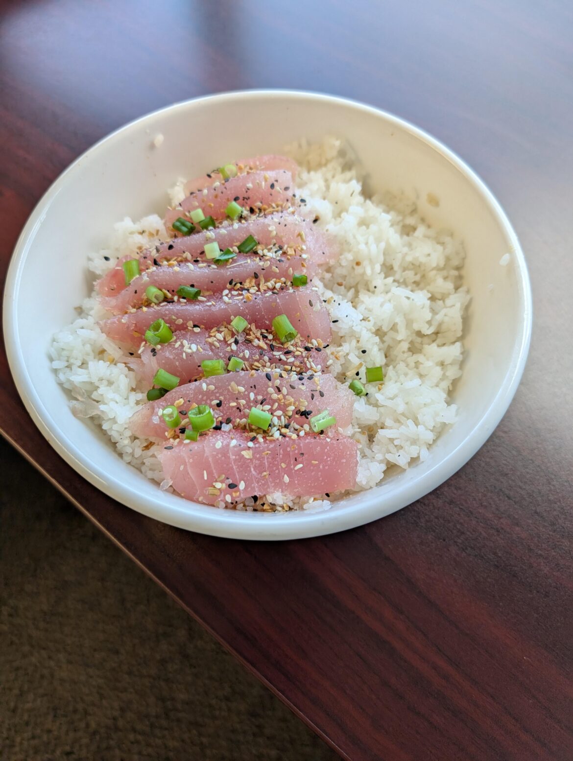 Albacore served over seasoned rice, garnished with scallions and everything seasoning