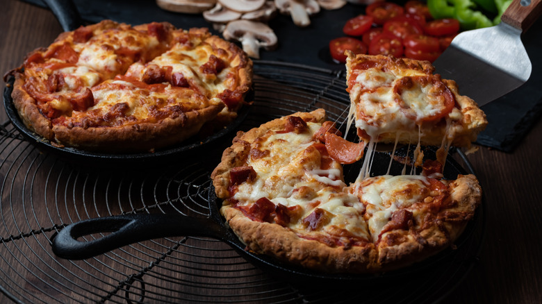 Two pizzas in cast iron skillets