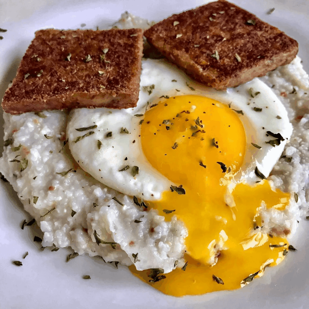 Sunny side up with deep fried scrapple on a bed of bacon cheddar grits.