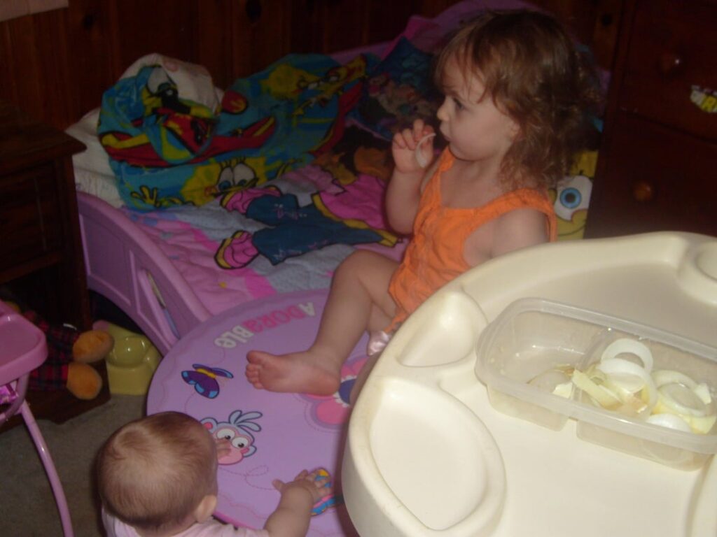 3 Year old me sitting/standing on the table eating a bowl of onions