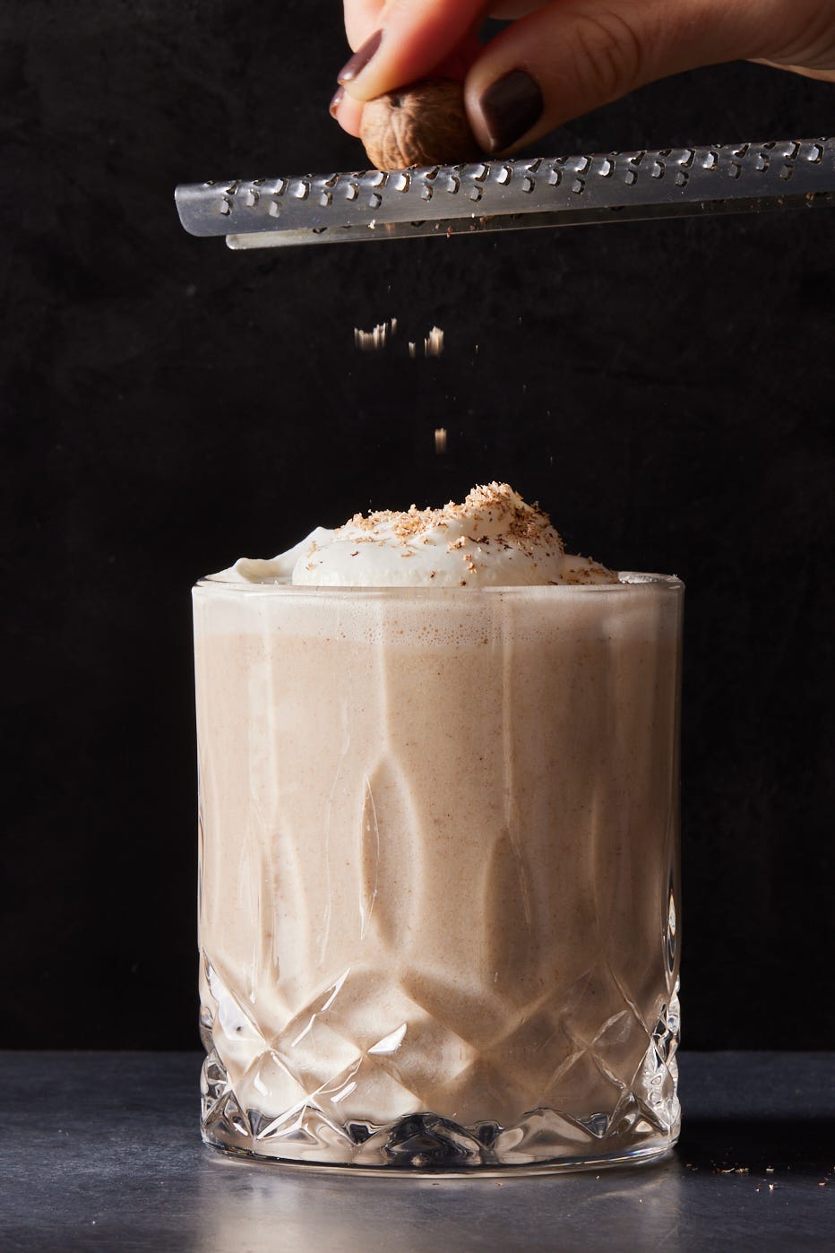 vegan eggnog topped with soy whipped cream and grated nutmeg