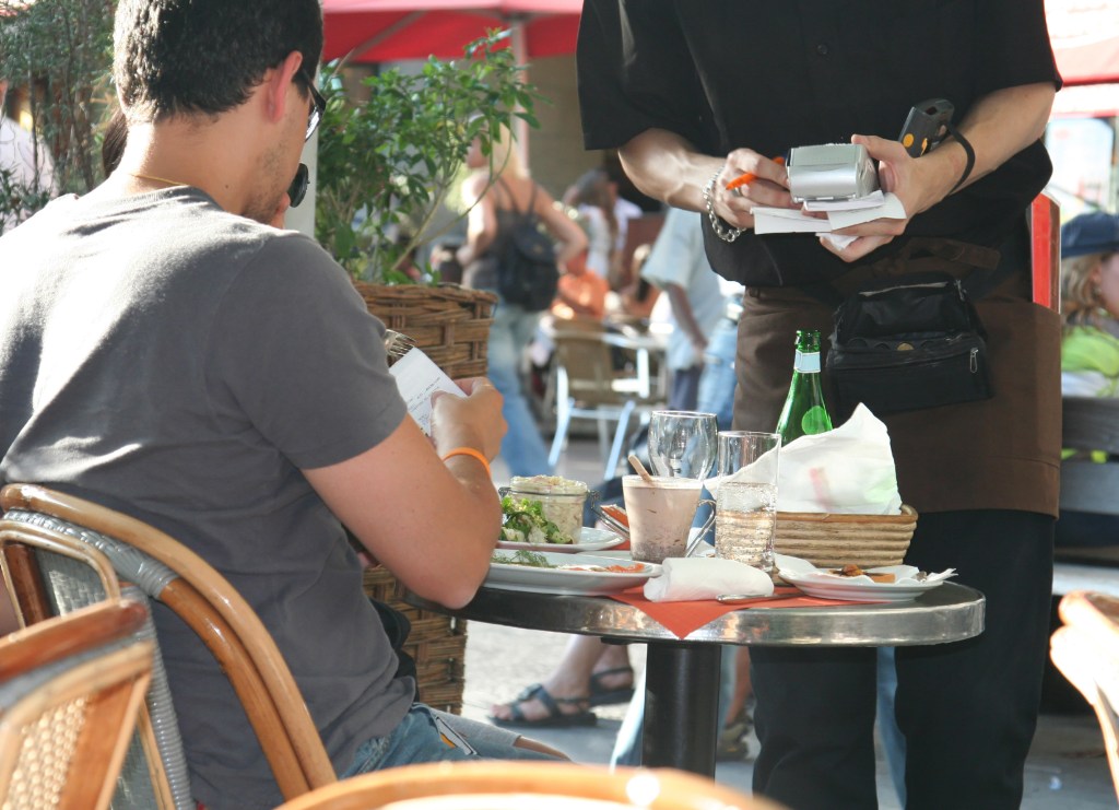 Customer paying by card at a cafe.