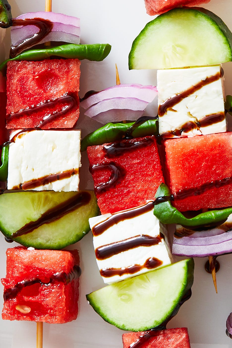 skewers with watermelon, feta, cucumber, basil, and red onion drizzled with a balsamic glaze