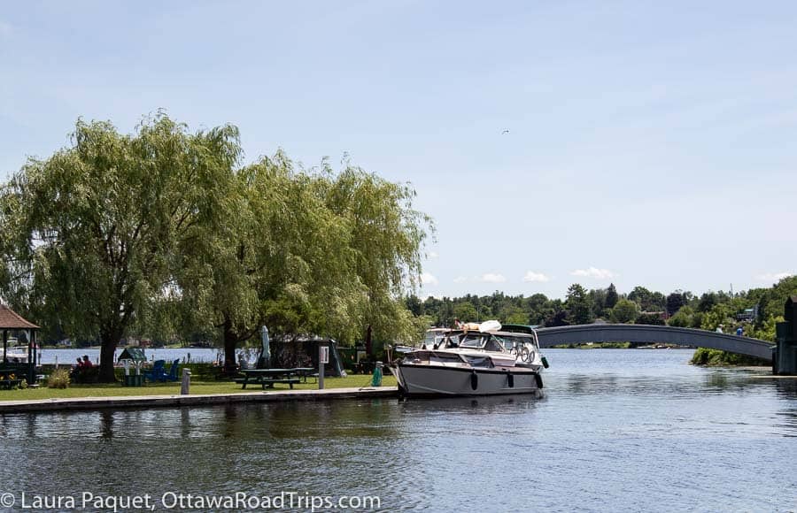 river with trees, a small boat and a picnic table