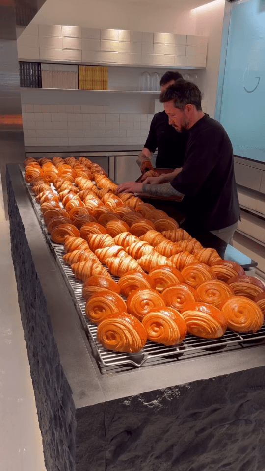 two men are working in a bakery making croissants